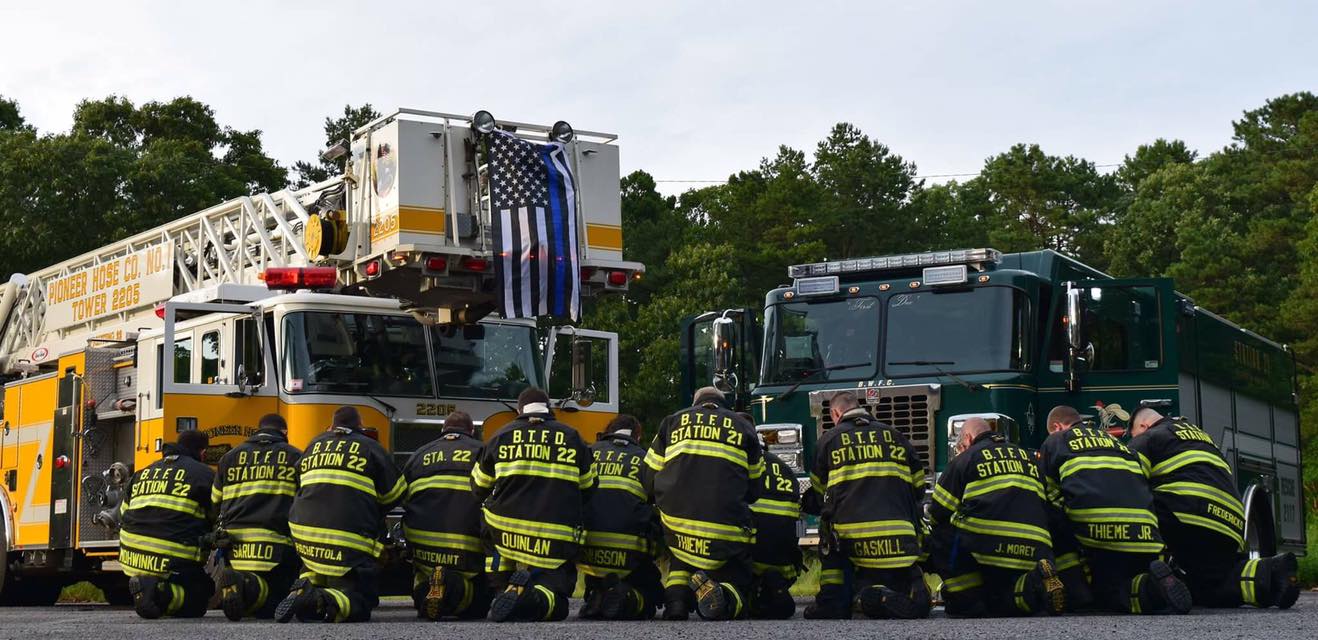 Firefighters from Brick Fire District No. 1 kneel in support of police officers. (Credit: Pioneer Hose Fire Company)