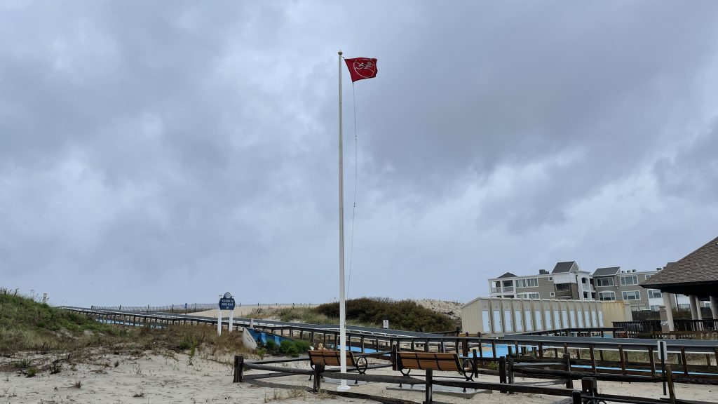 A red flag flies over cloudy skies at Brick Beach III, May 6, 2022. (Photo: Daniel Nee)
