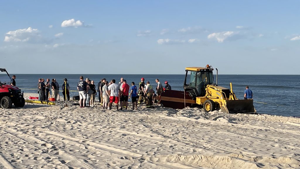 Rescue workers searching for a teen missing after a hole in the beach sand collapse, May 17, 2022. (Photo: Daniel Nee)