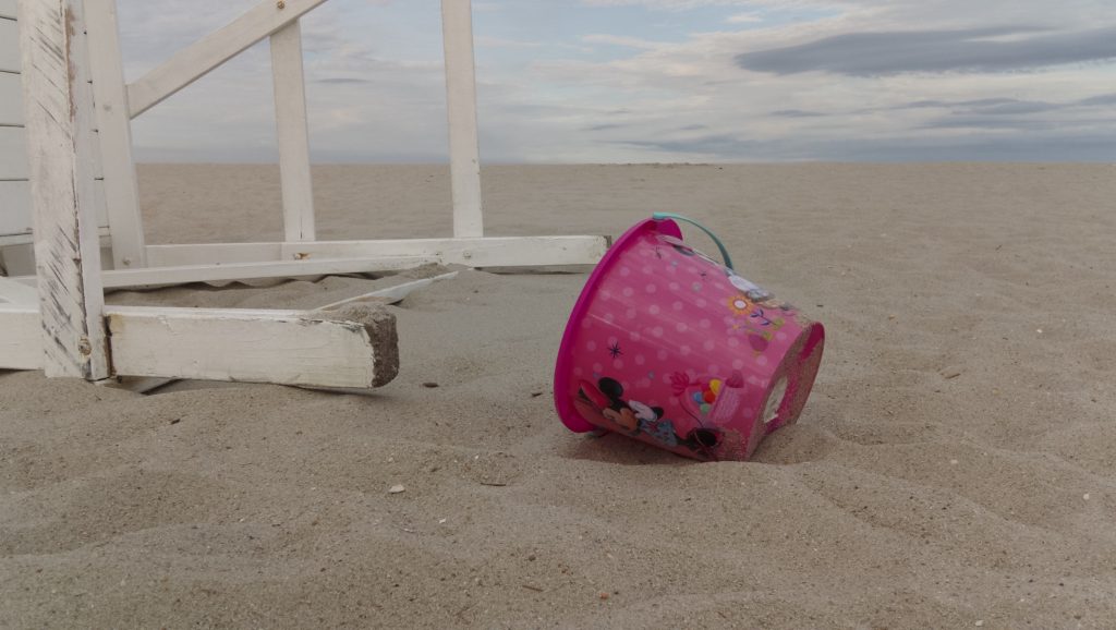 A beach sand pail next to a lifeguard chair in Seaside Heights, N.J., July 2022. (Photo: Daniel Nee)