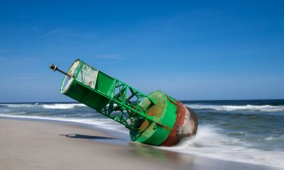 A green "13" buoy marker washes up in Seaside Heights, N.J., April 2026. (Credit: John Astrab/ Facebook)